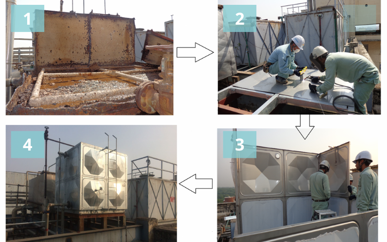 Two workers installing a large water tank on a concrete platform, positioning it carefully for proper placement.